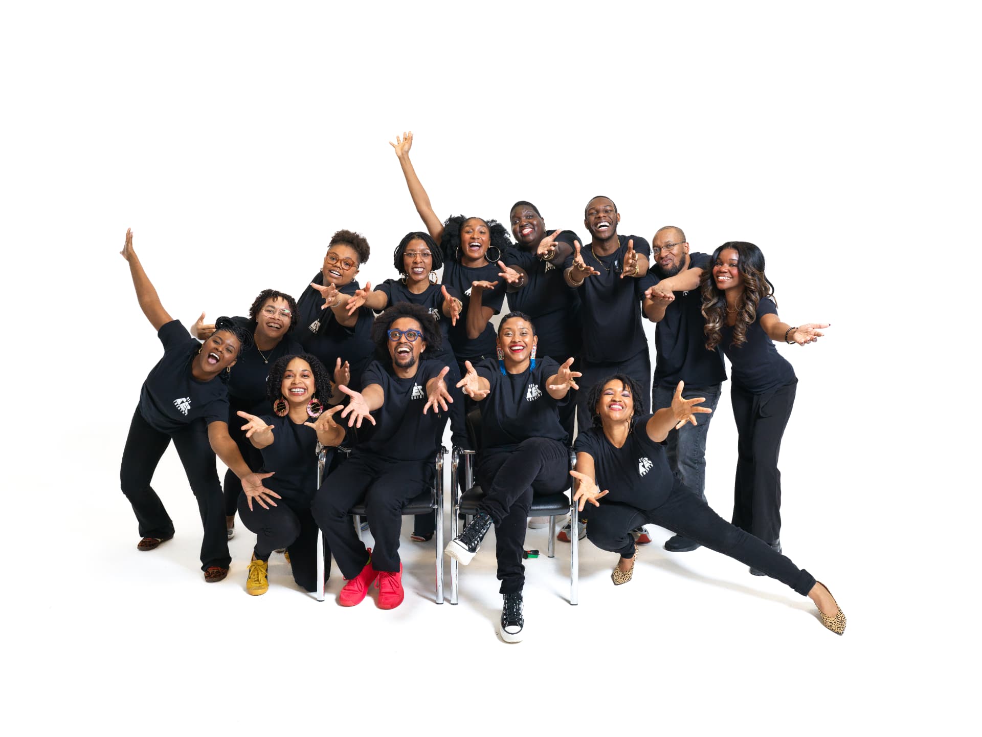 CFA community members in black foundation shirts reaching toward the camera in a studio portrait